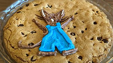 A cookie cake with the mouse from "When You Give a Mouse a Cookie" in frosting on top of it.