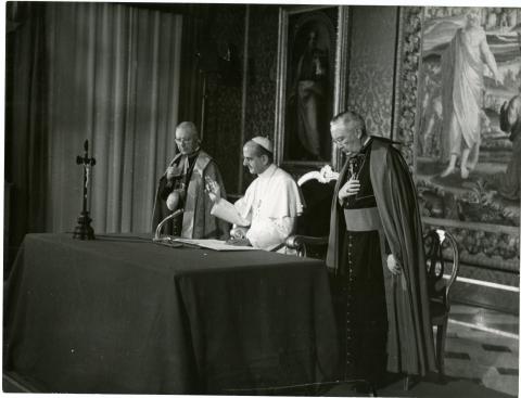 Pope Paul VI, with his hand raised speaks into a microphone during the Telstar telecast.