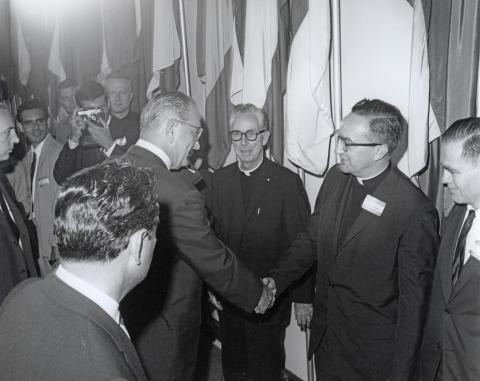 Black and white photograph of Lyndon Johnson shaking the hand of the Georgetown University President at the signing ceremony