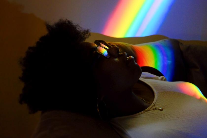 Reclining woman looks at rainbow