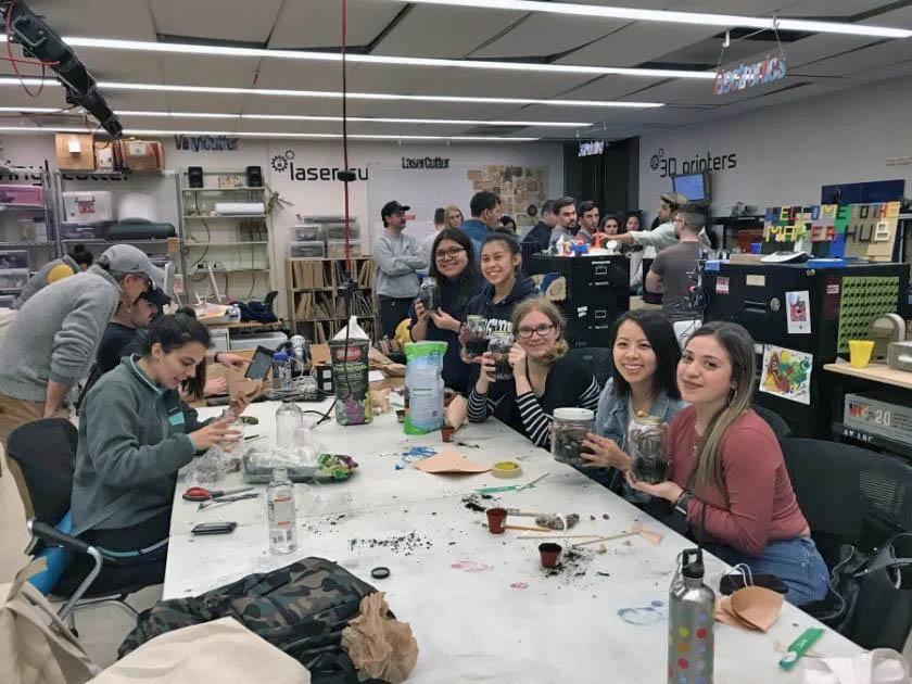 A group of students show their in-progress terrariums in the Maker Hub