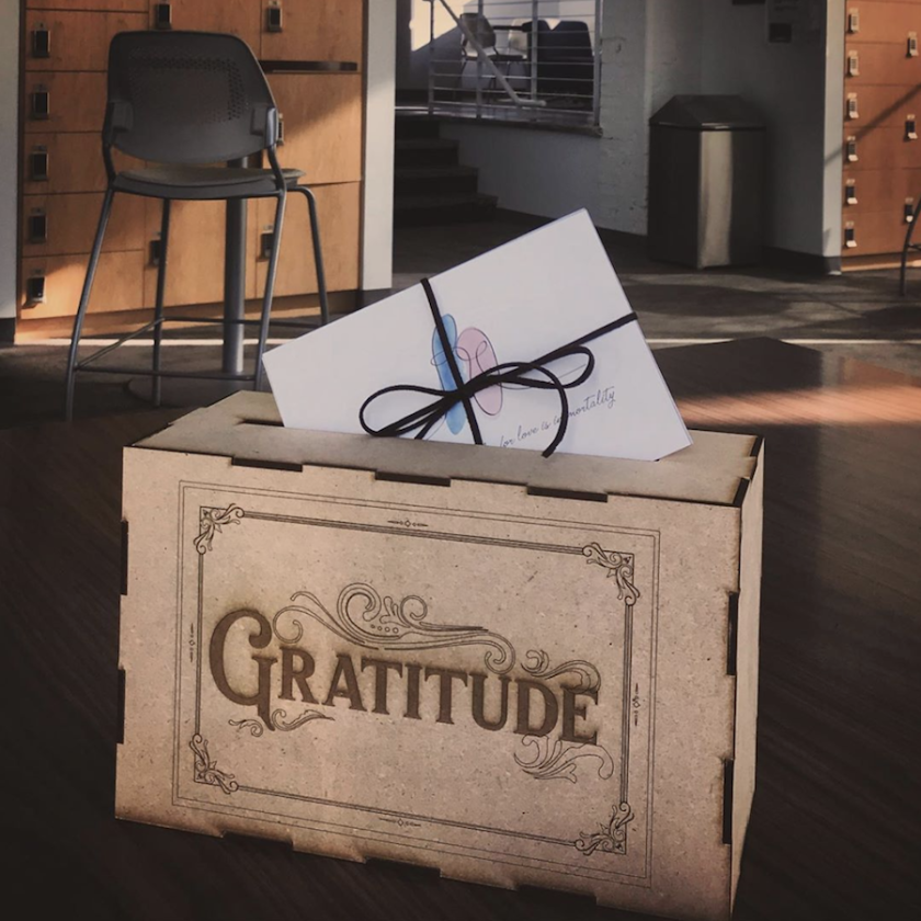 Lasercut box holding postcards with word "Gratitude" written on front 
