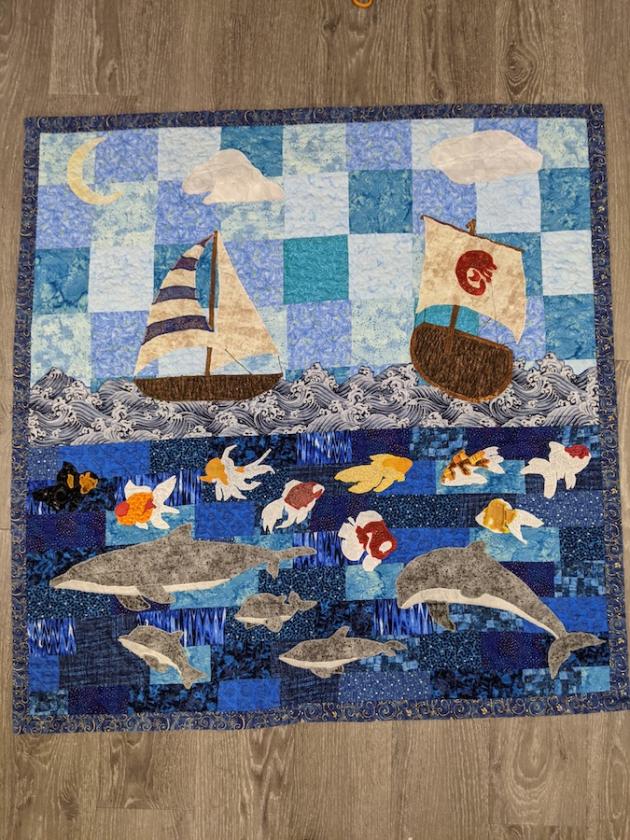 Quilt featuring boats, fish, and dolphins