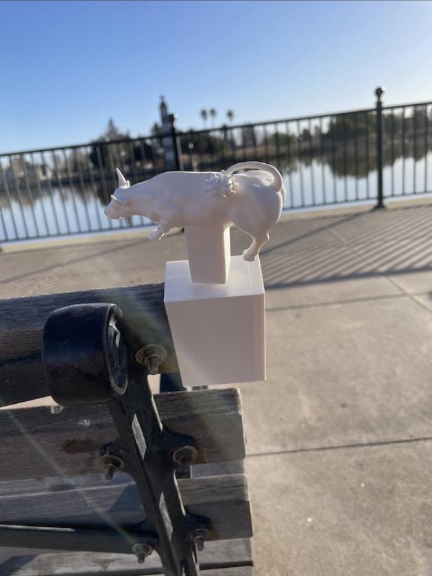 image of 3d printed bull with coronavirus tail, mounted on a park bench