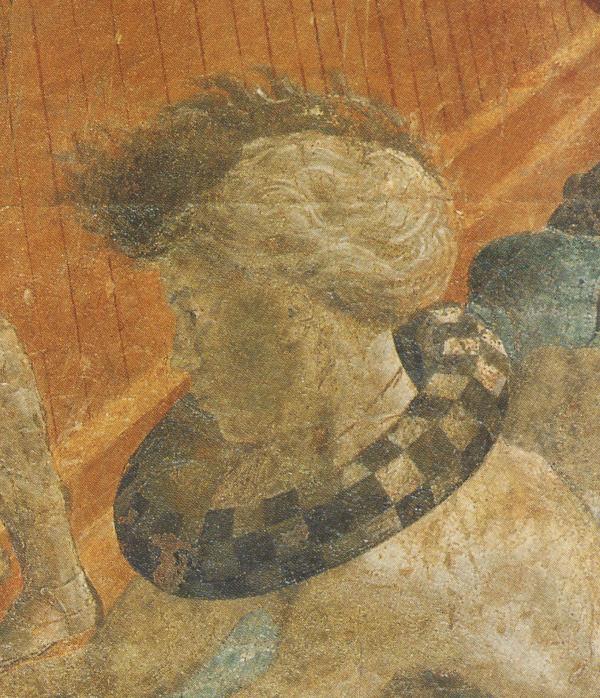 Side profile of a man with a checkered torus ring around his neck.