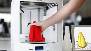 a hand removing a red 3d printed object from a 3D printer