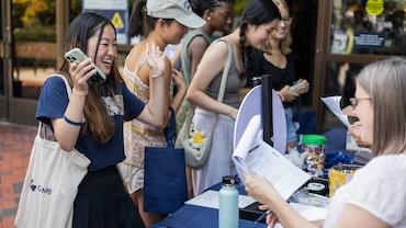 A happy femal student wins a prize at the library trivia wheel