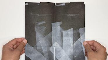 A piece of art held by hands on either side.