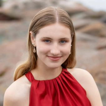 white woman in a red shift smiles at camera