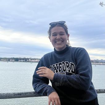 woman smiling while leaning against a railing