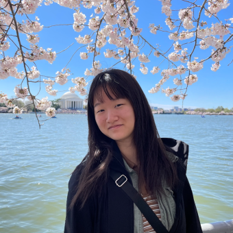 woman standing under flowering cherry tree