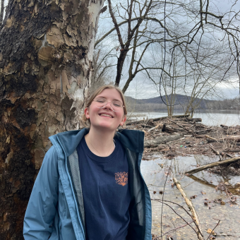 woman standing in front of water wearing a blue jacket