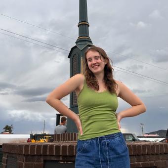 woman in green shirt smiling at camera