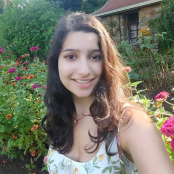 woman smiling and standing in a flower garden