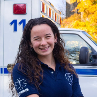 Smiling woman standing in front of an ambulance