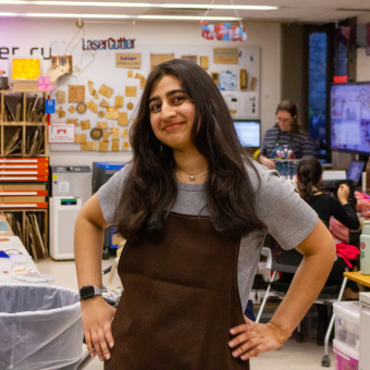 woman standing in brown apron smiling