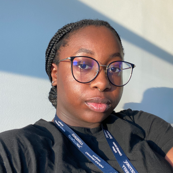 black woman sitting in front of a blue wall