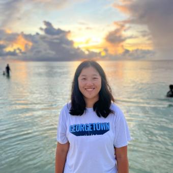 woman standing in front of an ocean sunset