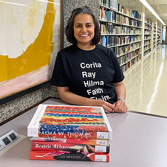 Book artist posing in front of books in a Library