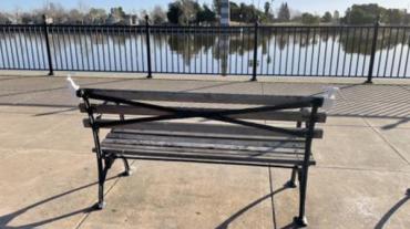 Bench overlooking water with 3d prints on the ends of each of the sides. 