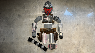 laid out pieces of 3d printed Mandalorain armor on a concrete slab floor