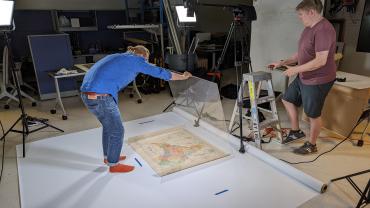 DSS unit employees using a copy stand to digitize a map of India