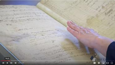 screen grab from the video showing a hand opening the logbook