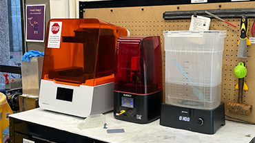 a lineup of three machines used to do resin printing