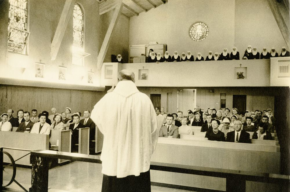 Priest giving mass with nuns in balcony