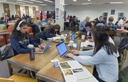 Dozens of students sit at tables on the Second floor of Lauinger Library, working on laptops, some with headphones on others chatting with their friends, from 2017