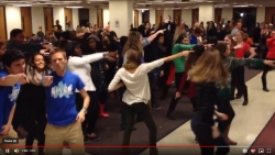 Close to one hundred students dance in the study area on the second floor of Lauinger Library